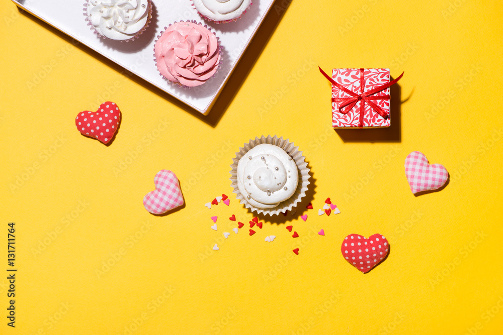 Delicious cupcake with paper box on yellow background