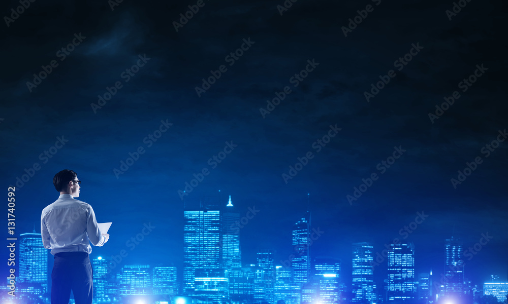 Businessman viewing night glowing city