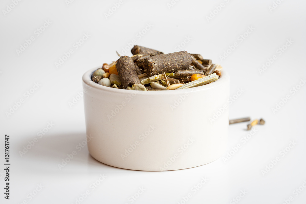 dry food for rodents in bowl white background