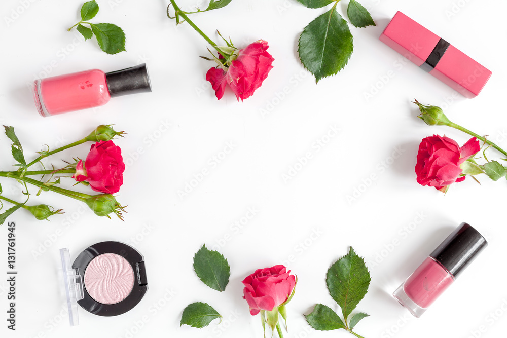 berry color decorative cosmetics with roses white background top view