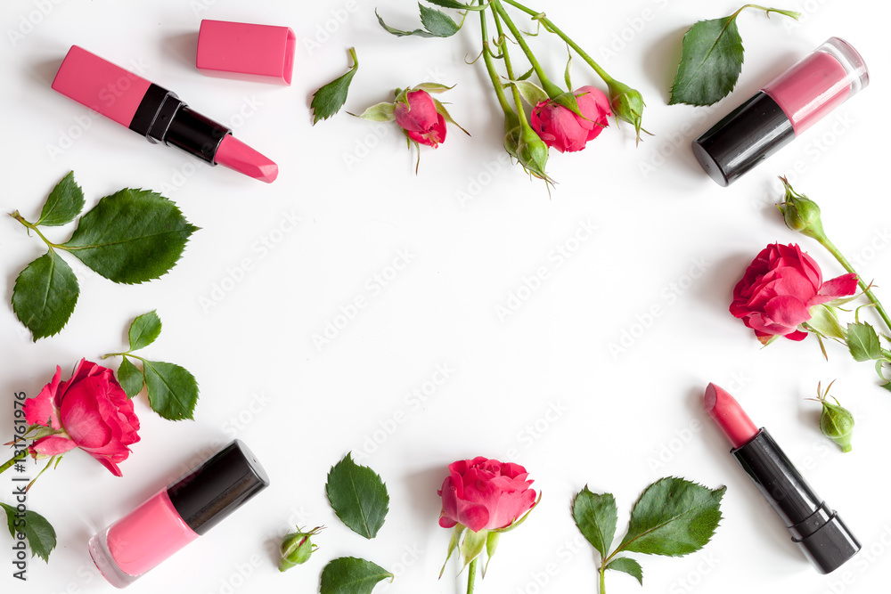 berry color decorative cosmetics with roses white background top view