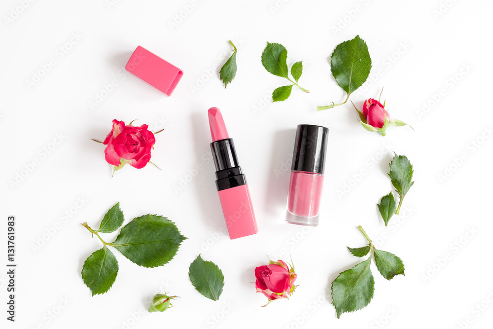 berry color decorative cosmetics with roses white background top view