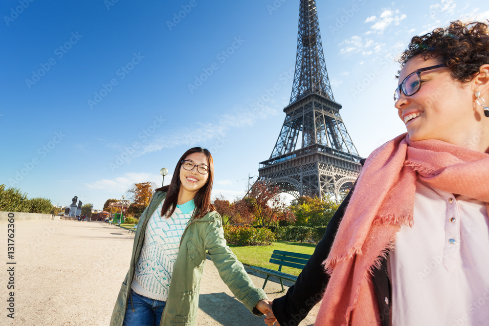 Two friends walking around Paris holding hands