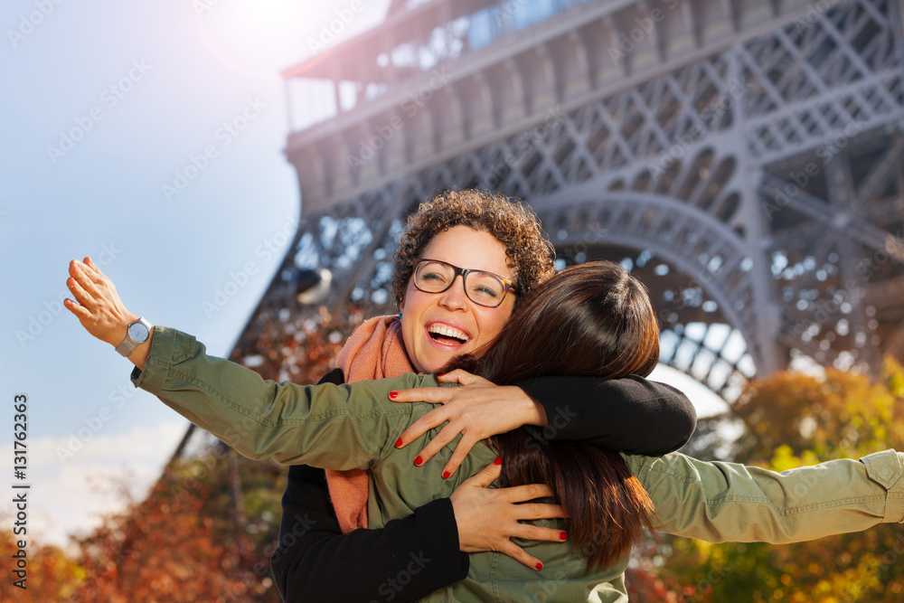 Friends meeting in the street of Paris and hugging