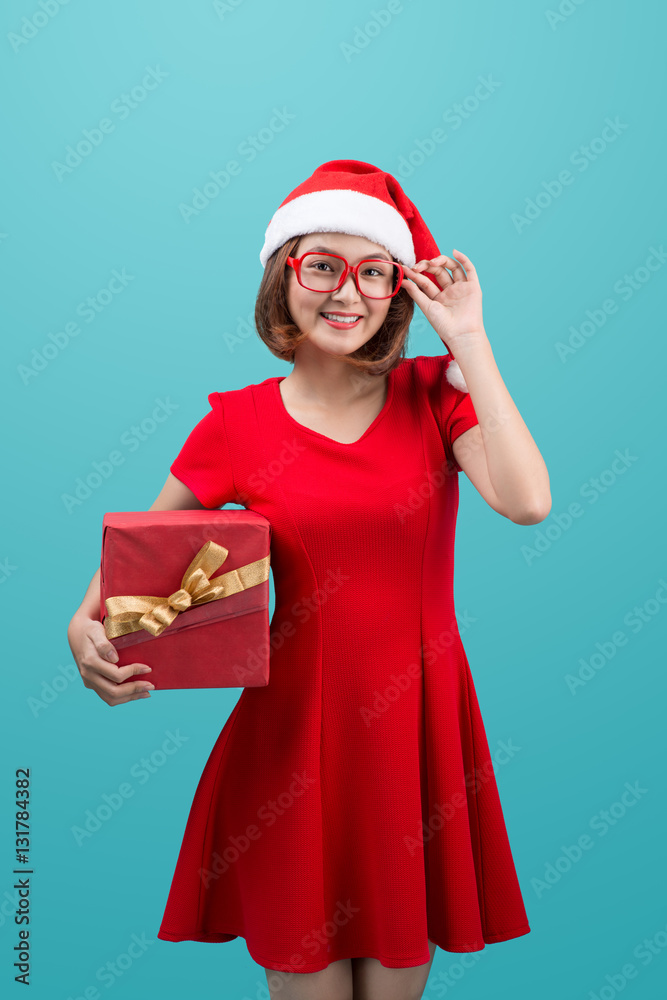 Smiling asian woman in red santa hat holding present box