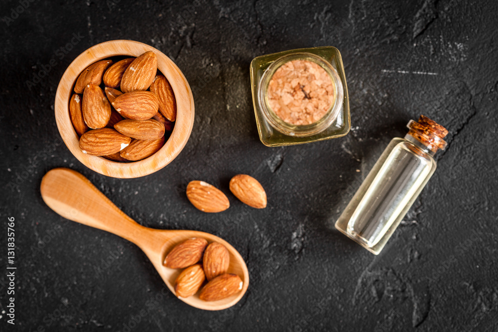 cosmetic almond oil in glass bottle on dark background