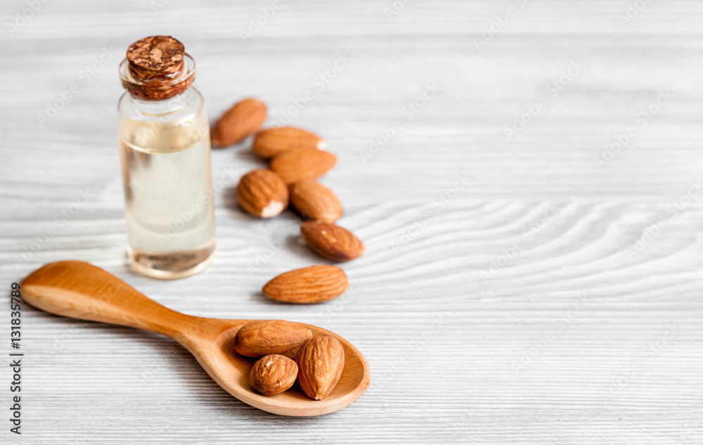 cosmetic almond oil in glass bottle on wooden background