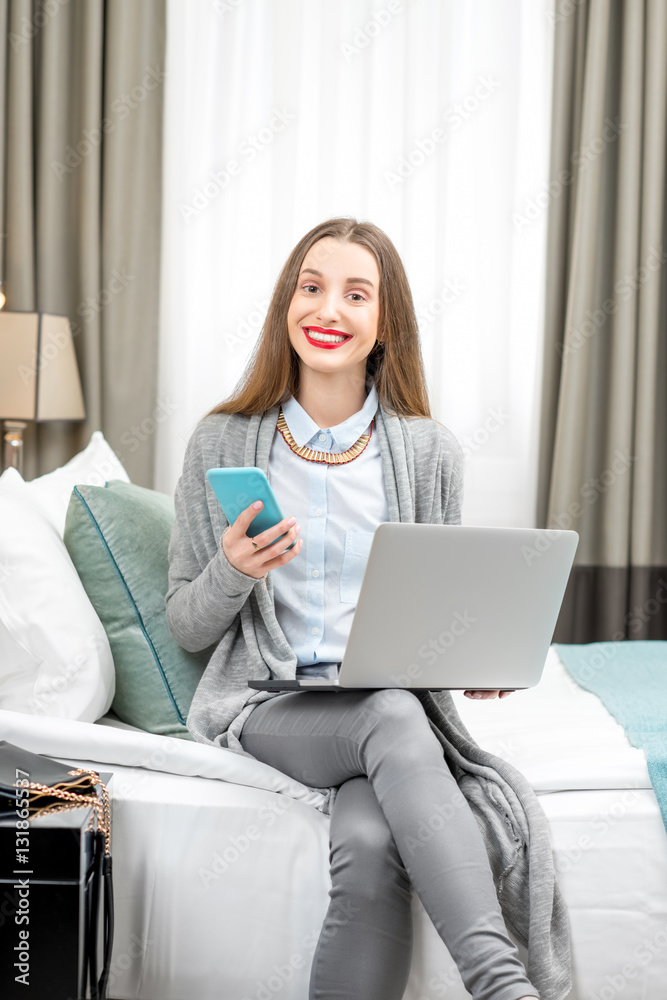 Business woman sitting with laptop in the luxury hotel room. Staying at the hotel during the busines