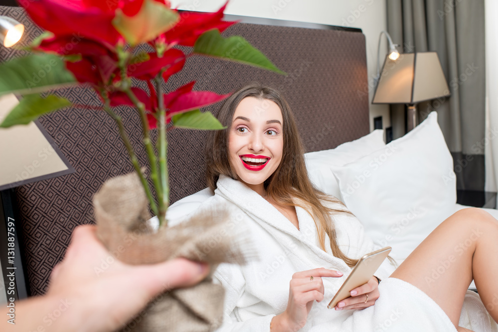 Surprised woman in the bed receiving a flower