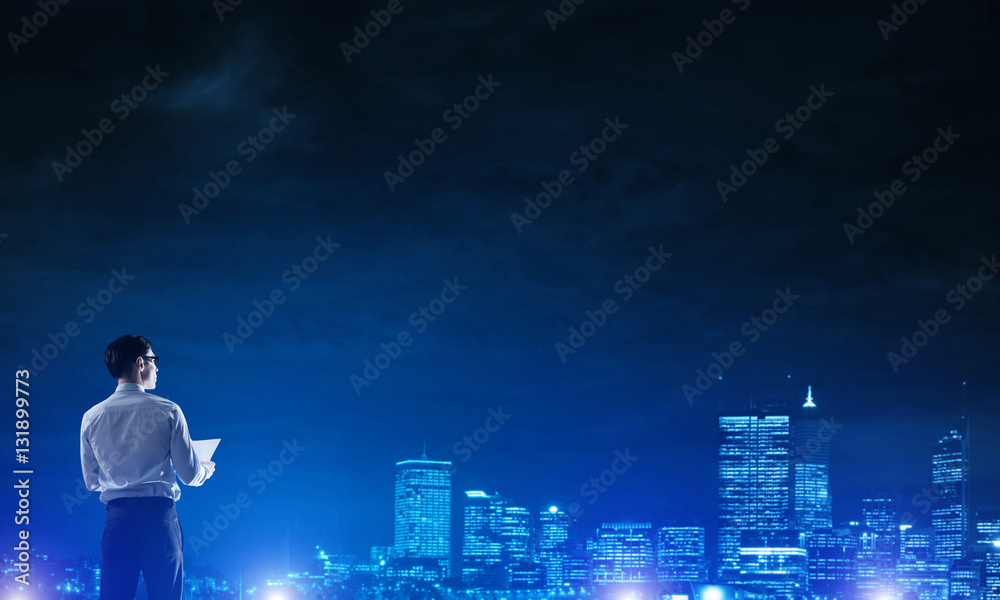 Businessman viewing night glowing city