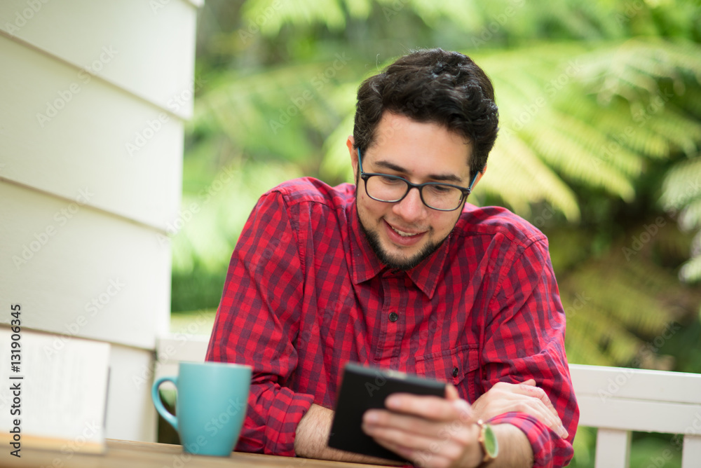 Young man with reader sitting outdoor