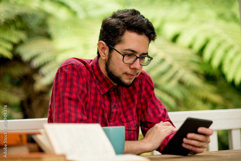 Young man with reader sitting outdoor