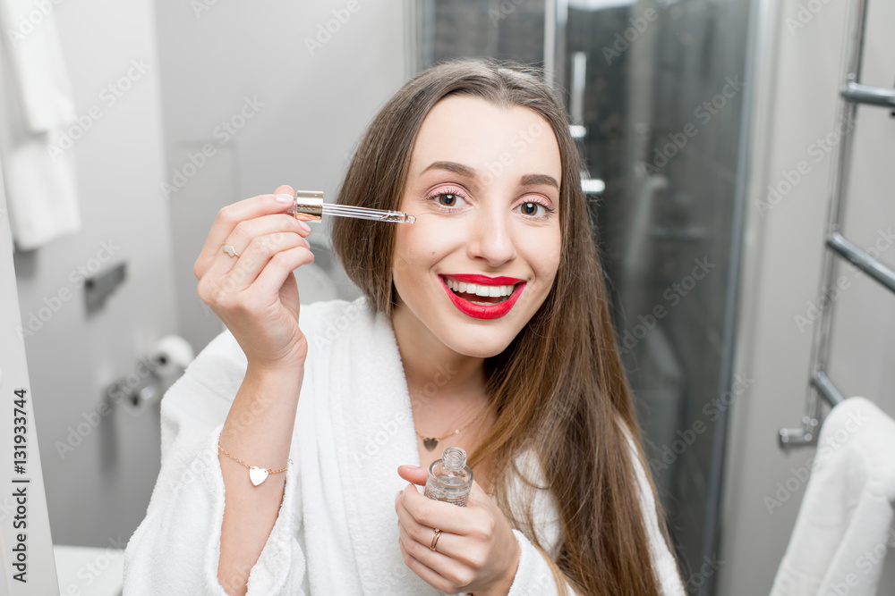 Woman with medicine dropper in the bathroom