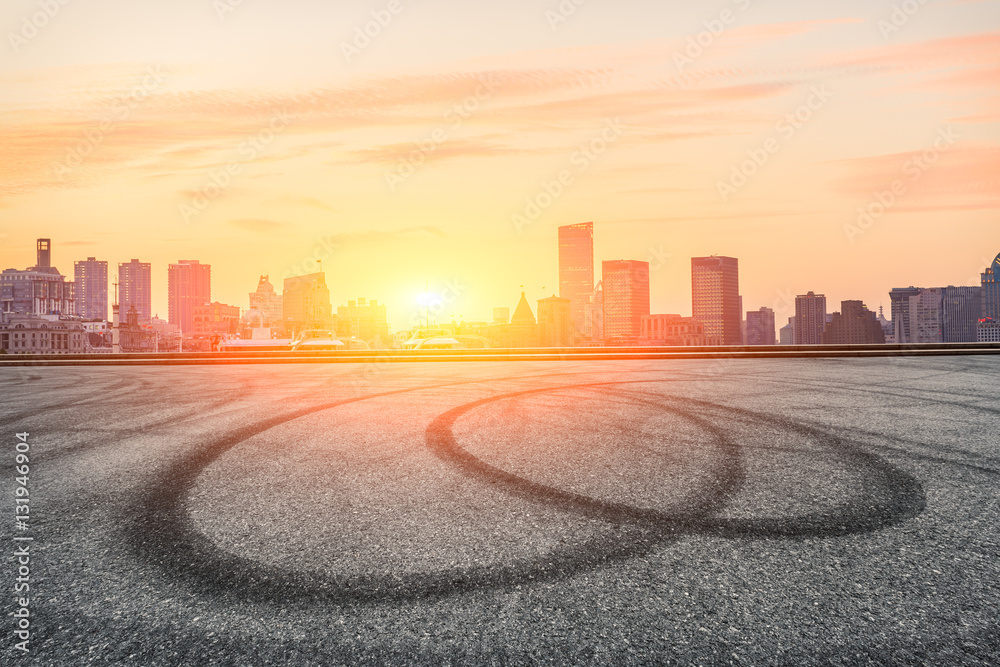 Asphalt road and modern cityscape at sunset in Shanghai