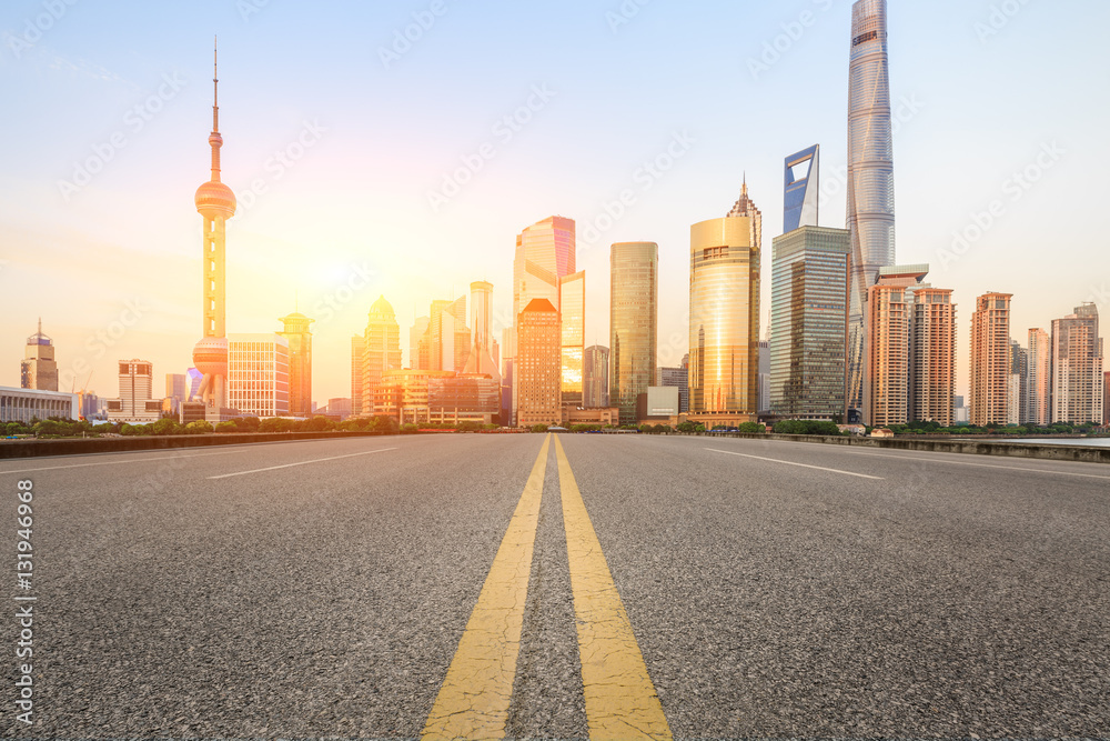 Asphalt road and modern cityscape at sunset in Shanghai