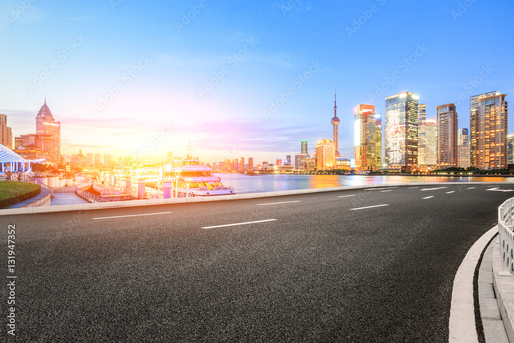 Asphalt road and modern cityscape at sunset in Shanghai