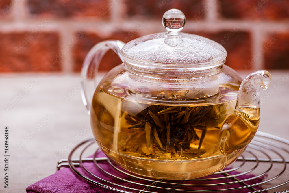 Glass teapot with tea on cooling rack. Front view.