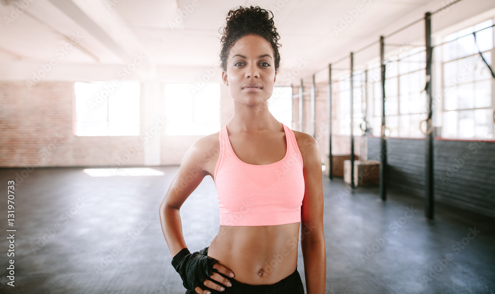 Confident young woman standing in gym