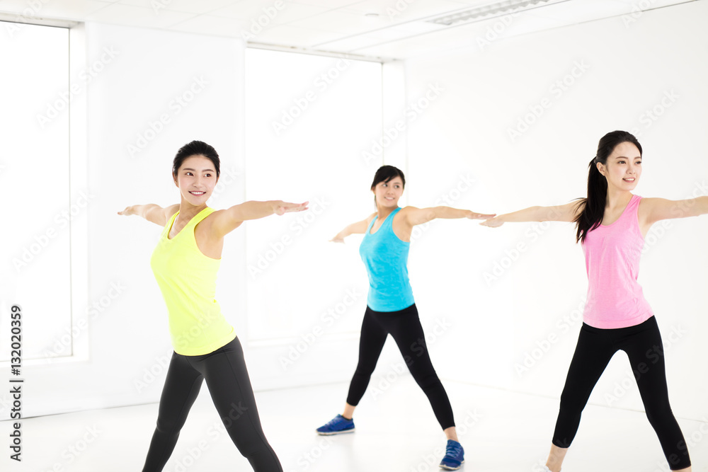 smiling young  group stretching in gym