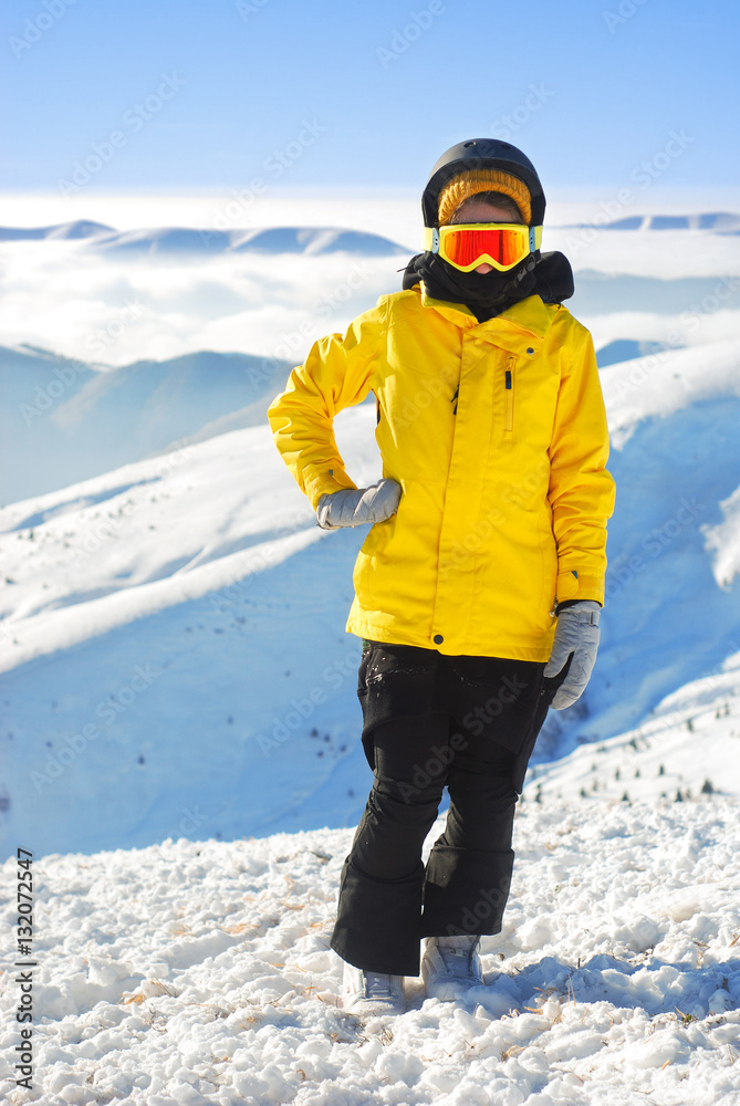 girl in snowboard equipment against the backdrop of snow-capped