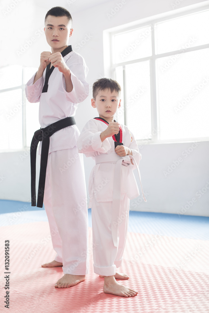 Young instructor teaching boy Tae Kwon Do