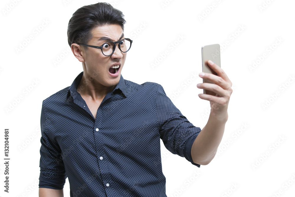 Angry young man looking at smart phone