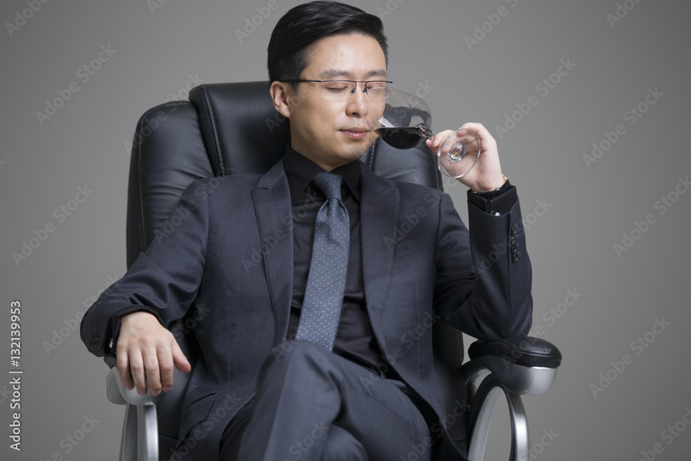 Mid adult businessman enjoying red wine