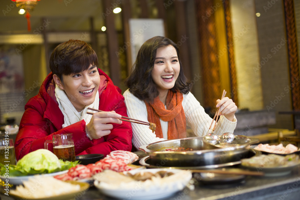 Young couple having dinner in hotpot restaurant