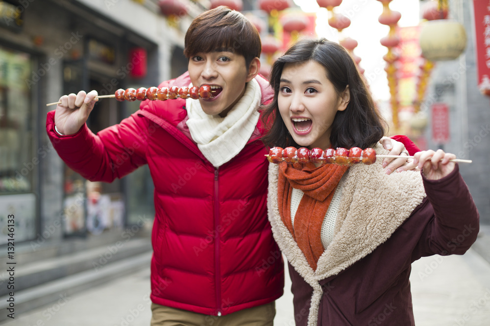 Young couple with candied haw berries celebrating Chinese New Year