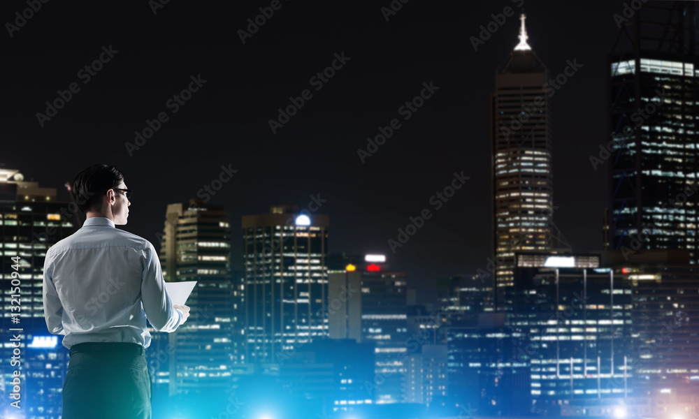 Businessman viewing night glowing city