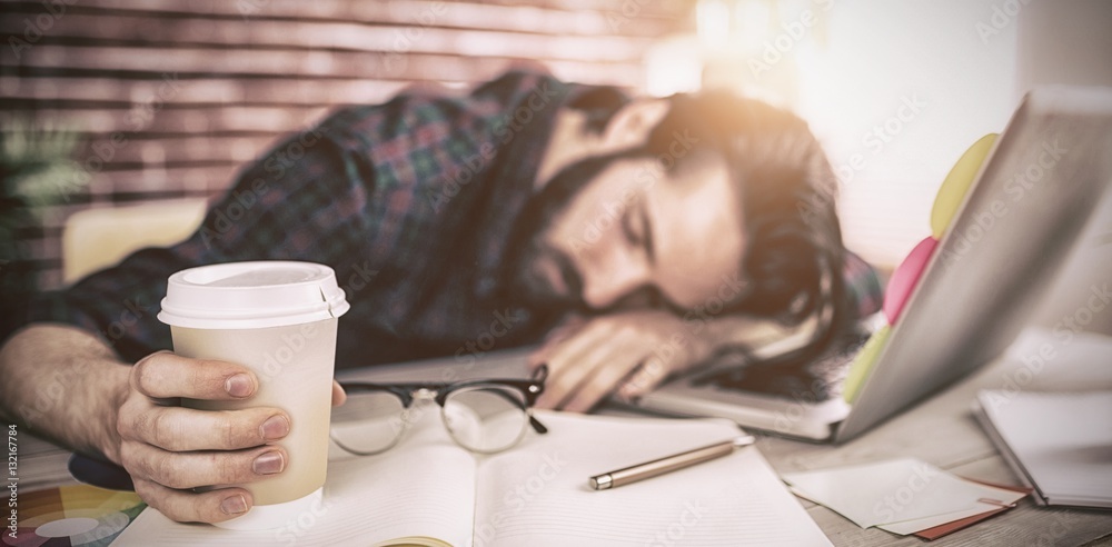 Tired creative editor holding disposable cup