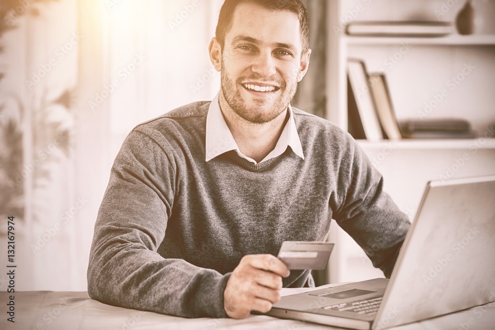 Male with credit card at his laptop