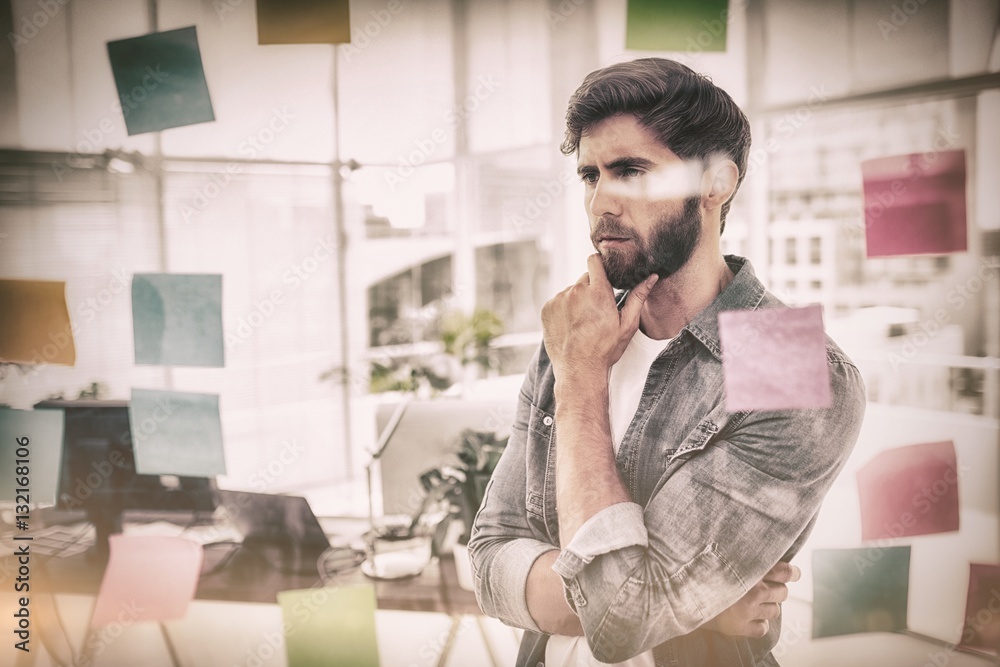 Puzzled businessman looking post its on the wall