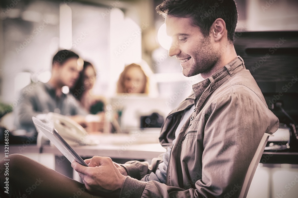 Smiling young man using digital tablet