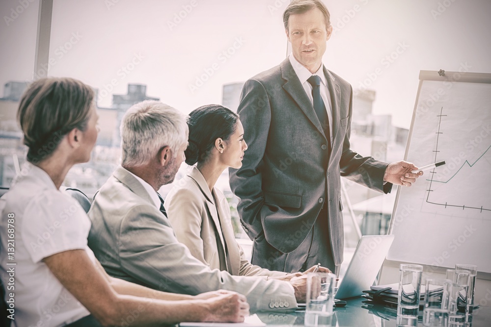 Businessman pointing at whiteboard during a meeting