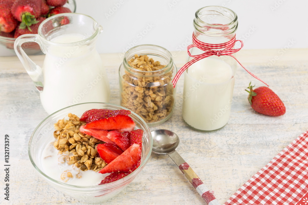 Granola cereals, fresh strawberries and bottle of milk