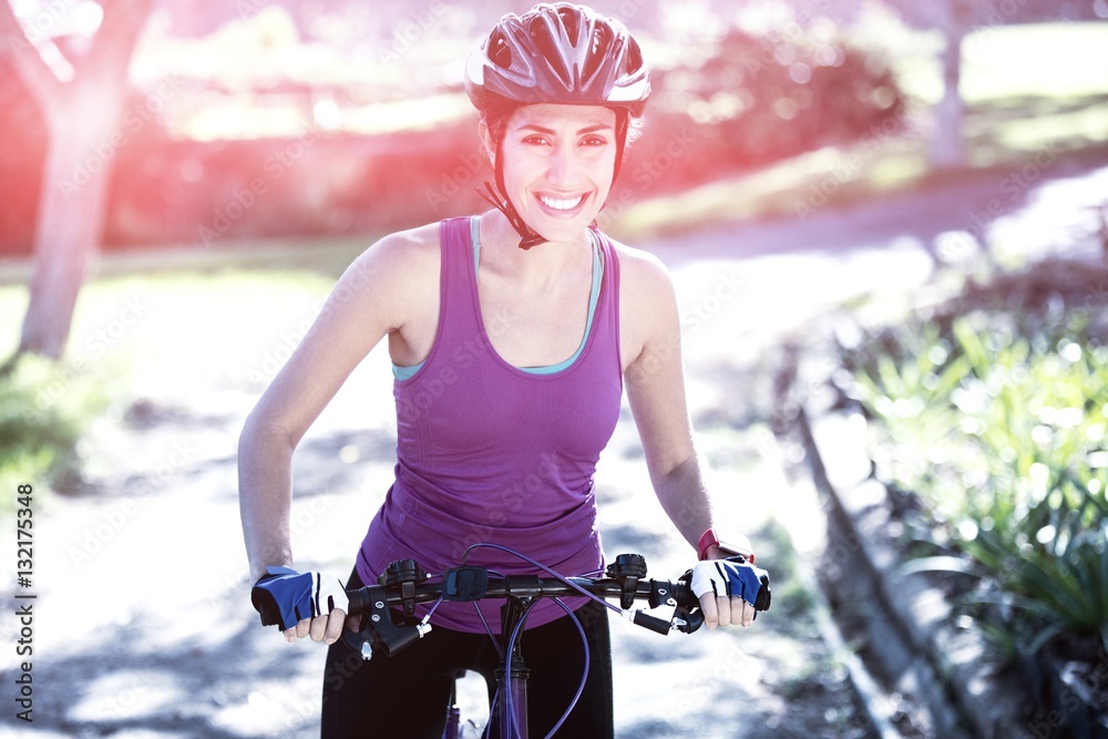 Portrait of female cyclist cycling in countryside on sunny day