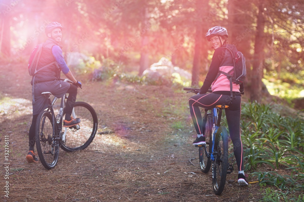 Portrait of biker couple with mountain bike in countryside