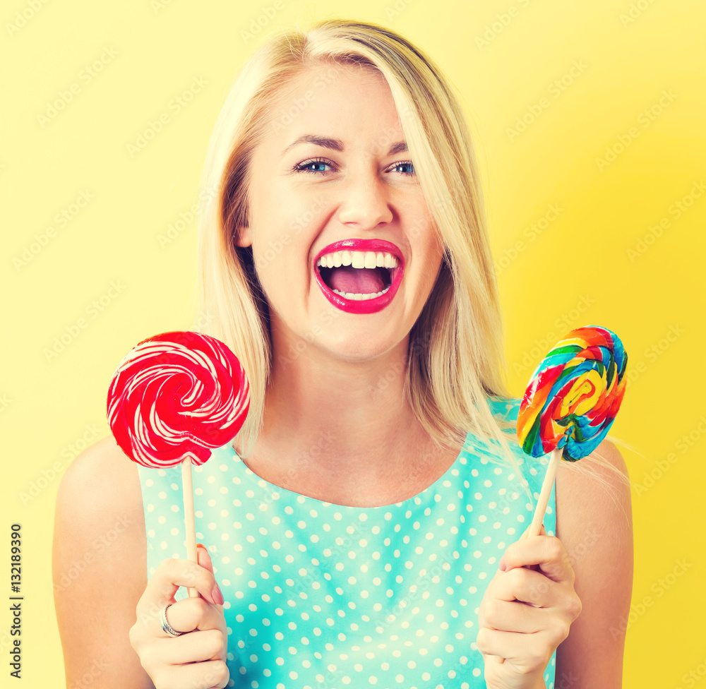 Young woman holding lollipops