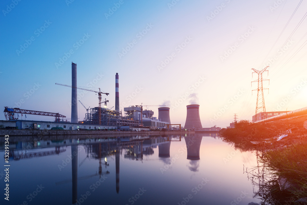 modern waterfront power plant at sunset