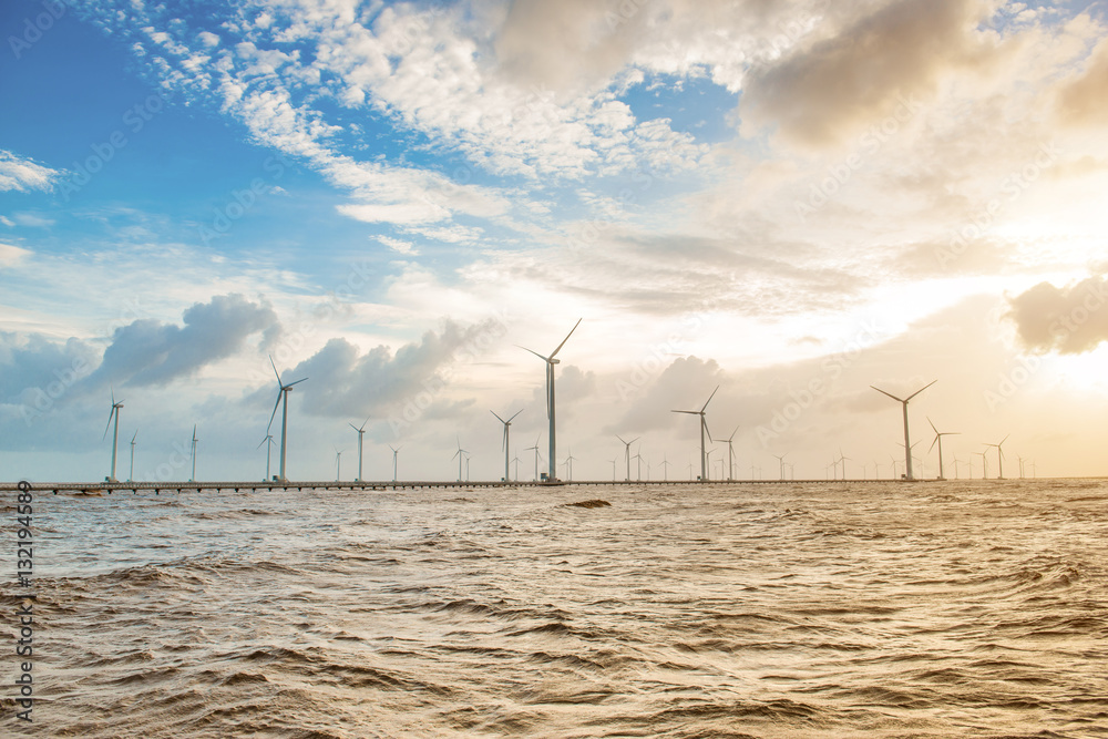 Wind turbines at sunset. Ecology wind against cloudy sky background