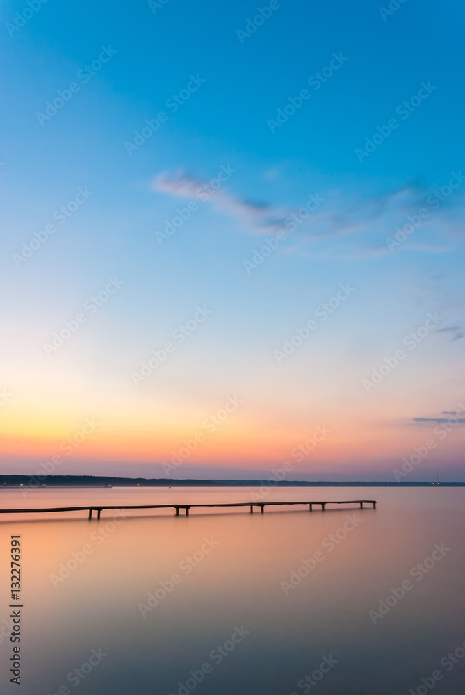 Old wooden pier on a lake at sunrise