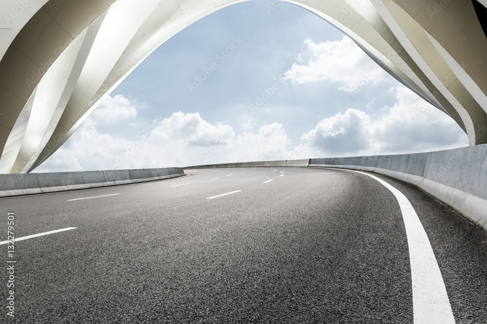 Asphalt road in front of modern bridge construction