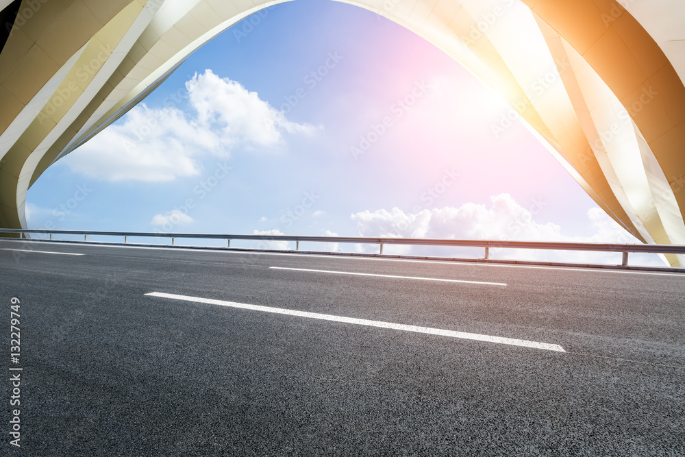 Asphalt road in front of modern bridge construction