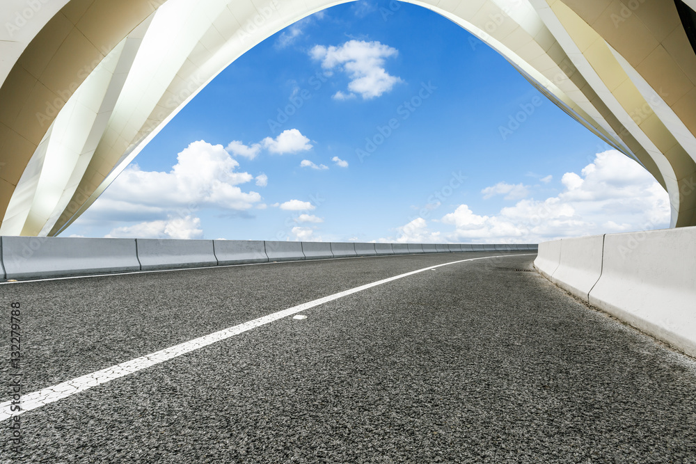 Asphalt road in front of modern bridge construction