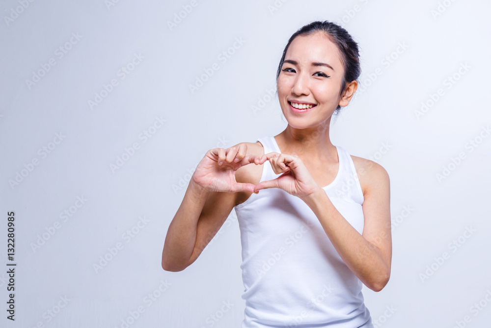 Beautiful smiling girl holding hands in heart shape framing. Asi