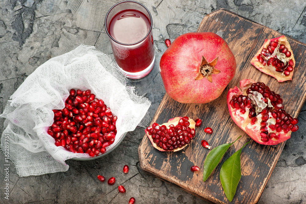 Pomegranate fruits with grains and leaves on the table. Make juice. Top view.