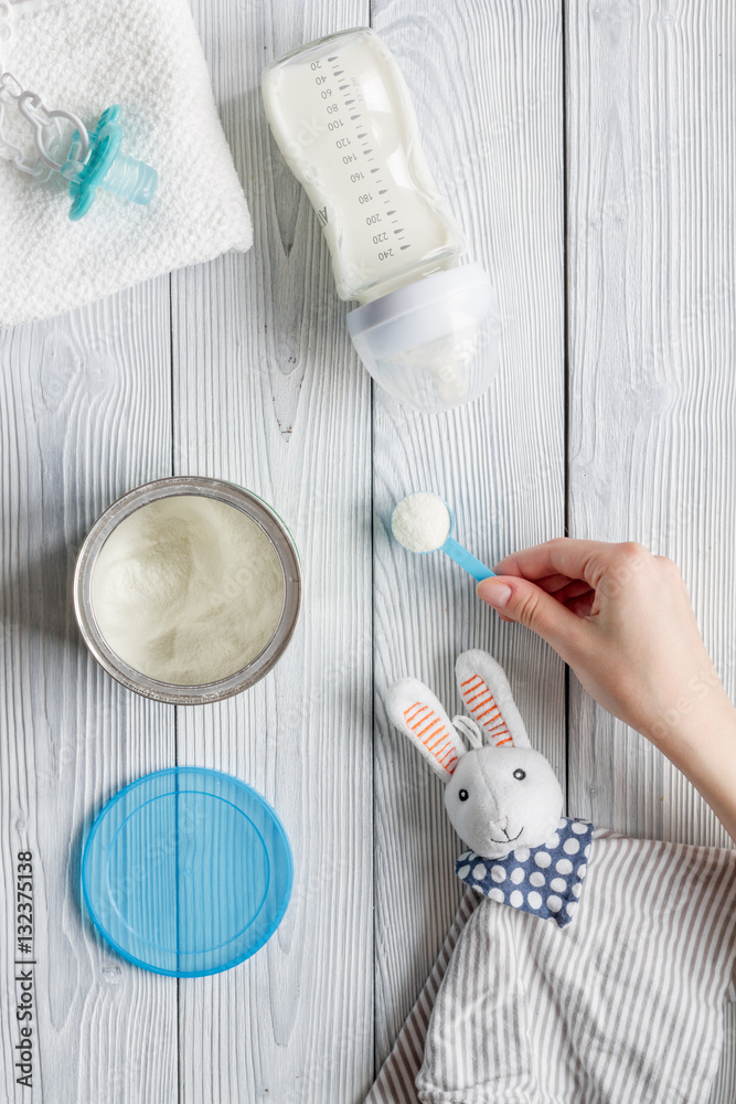 preparation of mixture baby feeding on wooden background top view