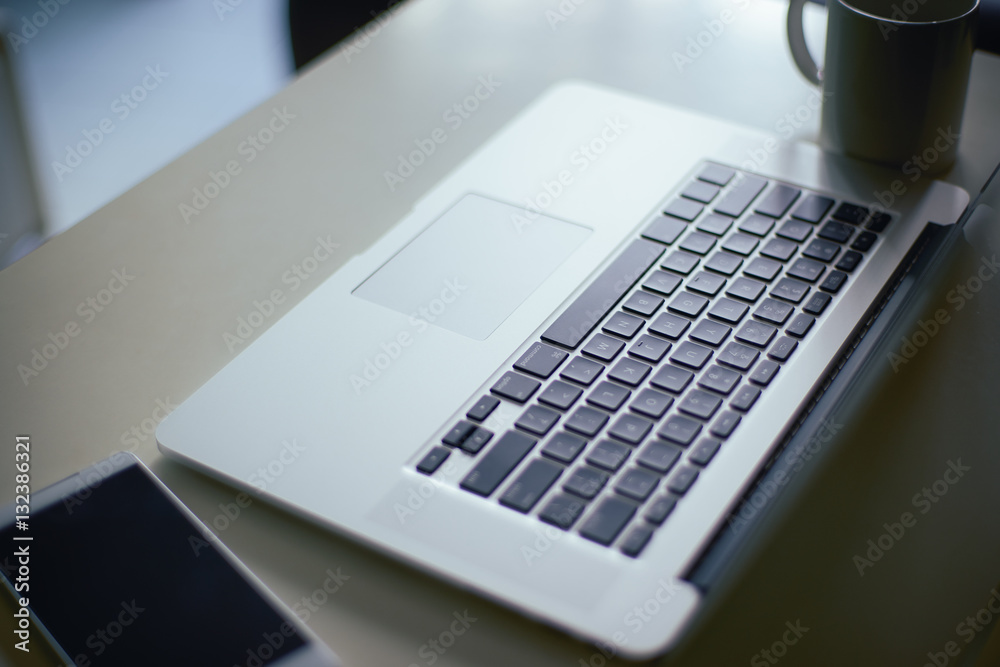 Comfortable working place. Close-up of comfortable working place in office with wooden table and lap