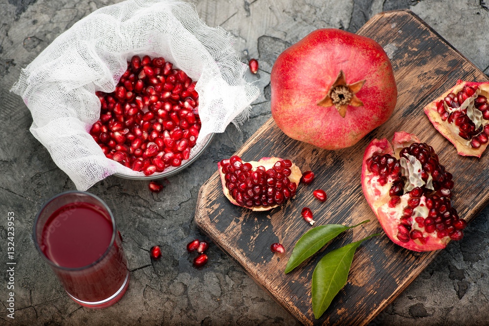 Pomegranate fruits with grains and leaves on the table. Make juice. Top view.